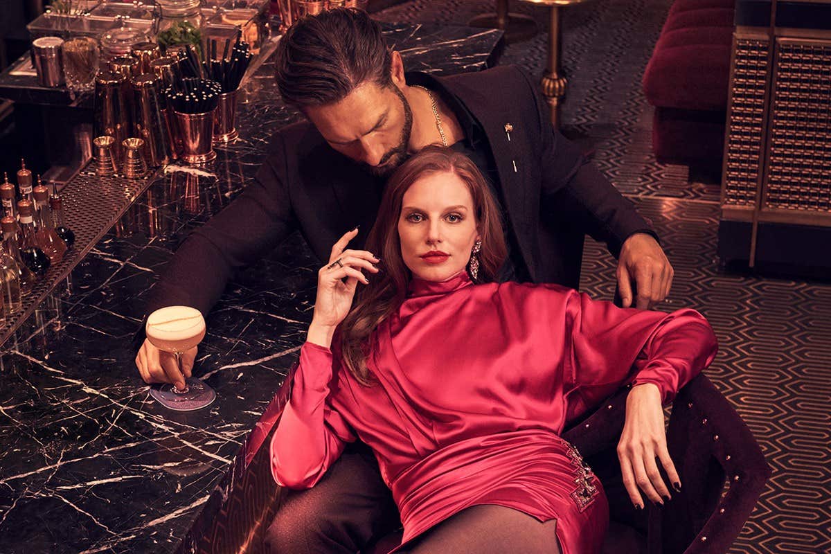 A woman lounging with her date while having a cocktail a cocktail.