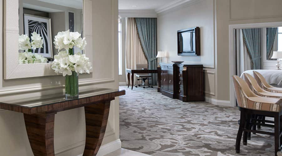Entrance into a suite with fresh flowers on a table.